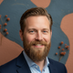Portrait of a happy Dutch man with a well-groomed beard, looking confident and satisfied.